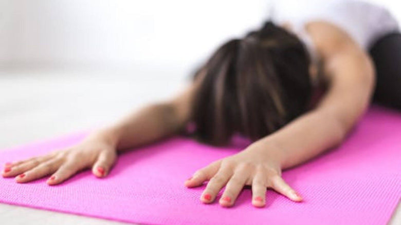 Women in yoga child's pose about to move to downward dog